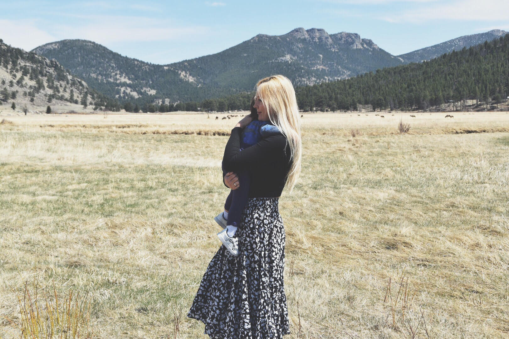 Mama and Child hug in front of mountains