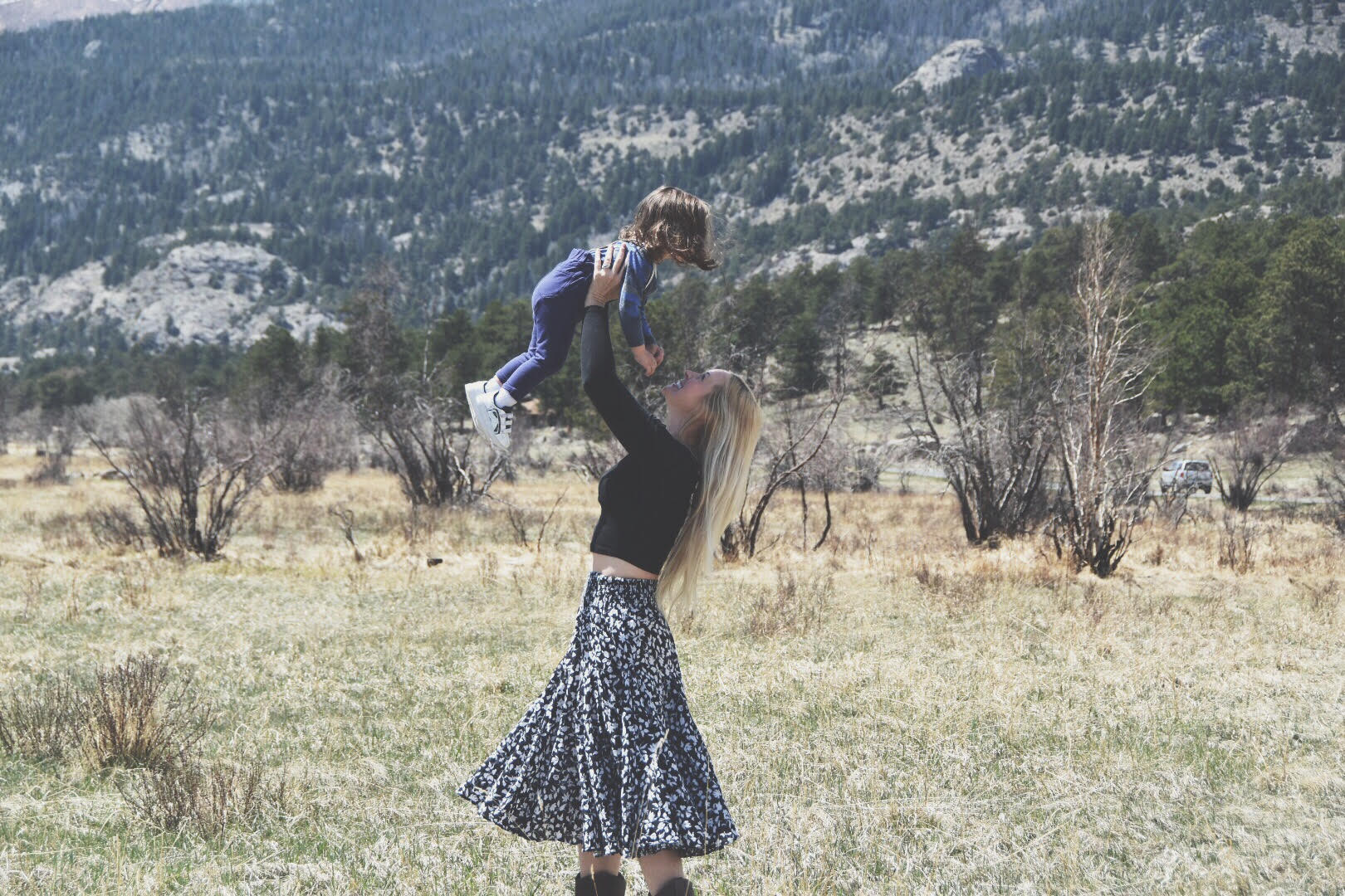 Mama and Child dance in front of mountains